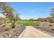 Scenic view of the community green with a paved walkway, perfect for a leisurely stroll amidst beautiful landscaping at 22282 N 184Th Ln, Surprise, AZ 85387