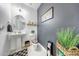 Cozy half-bathroom with a pedestal sink, decorative mirror, and dark accent wall at 22282 N 184Th Ln, Surprise, AZ 85387