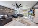 Spacious living room with a large sectional sofa, wood accent wall, and modern ceiling fan at 22282 N 184Th Ln, Surprise, AZ 85387