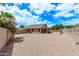 Expansive backyard with gravel landscaping, mature trees, covered patio, and block fence for privacy at 22683 N Aaron Rd, Maricopa, AZ 85138
