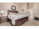 Comfortable bedroom featuring neutral decor, carpet flooring, and a dark-wood frame bed at 22683 N Aaron Rd, Maricopa, AZ 85138
