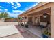 A charming covered patio area with a swing, hanging planters, and easy access to the backyard at 22683 N Aaron Rd, Maricopa, AZ 85138