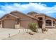 Well maintained exterior with an attached three-car garage and desert landscaping at 22683 N Aaron Rd, Maricopa, AZ 85138