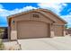 Attached three-car garage with a spacious driveway and desert landscaping at 22683 N Aaron Rd, Maricopa, AZ 85138
