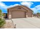 Attached three-car garage with a spacious driveway and desert landscaping at 22683 N Aaron Rd, Maricopa, AZ 85138