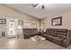 Inviting living room featuring tile flooring, neutral walls, and comfortable brown leather sofas at 22683 N Aaron Rd, Maricopa, AZ 85138