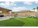 Backyard with a covered patio, artificial grass, fenced pool, and seating at 2306 E Parkside Ln, Phoenix, AZ 85024