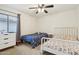 Bright bedroom featuring two comfortable beds, a ceiling fan, and a window with natural light at 2306 E Parkside Ln, Phoenix, AZ 85024