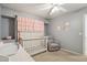 Inviting Bedroom featuring a crib, dresser, soft gray chair, and playful wall décor at 2306 E Parkside Ln, Phoenix, AZ 85024