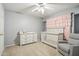 Cozy Bedroom featuring a crib, dresser, accent chair, and pink curtain accents at 2306 E Parkside Ln, Phoenix, AZ 85024