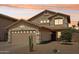 Sunset view of a charming two-story home with desert landscaping and a two-car garage at 2306 E Parkside Ln, Phoenix, AZ 85024