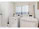 Functional laundry room equipped with a modern washer and dryer set, plus a window at 2306 E Parkside Ln, Phoenix, AZ 85024