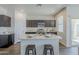 Kitchen island with stainless steel appliances, breakfast bar, dark cabinets and white countertops at 2625 W Gaby Rd, Phoenix, AZ 85041