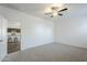 Carpeted main bedroom with ceiling fan with view of the kitchen at 2625 W Gaby Rd, Phoenix, AZ 85041
