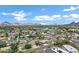 Expansive aerial view of a residential neighborhood with mountain views and lush green landscaping under a clear blue sky at 3046 E Glenrosa Ave, Phoenix, AZ 85016