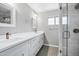 Bright bathroom featuring a double vanity, quartz countertop, modern fixtures, and a frameless glass enclosed shower at 3046 E Glenrosa Ave, Phoenix, AZ 85016