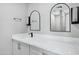 Bathroom vanity with quartz countertop, dark modern hardware and arched mirrors with sconces at 3046 E Glenrosa Ave, Phoenix, AZ 85016