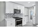 Modern kitchen features stainless steel appliances, sleek cabinetry, and stylish herringbone backsplash at 3046 E Glenrosa Ave, Phoenix, AZ 85016