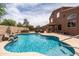 Resort-style backyard features a pristine pool, hot tub, covered patio with bar, and a manicured lawn at 3488 N Lady Lake Ln, Casa Grande, AZ 85122