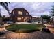 Spacious backyard with a putting green, pool, spa, and patio area with outdoor seating, perfect for recreation and relaxation at 3488 N Lady Lake Ln, Casa Grande, AZ 85122