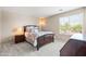 Well-lit bedroom with a comfortable bed, side table, and a sunlit window at 3488 N Lady Lake Ln, Casa Grande, AZ 85122
