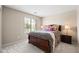 Inviting bedroom with a wood-frame bed, stylish bedding, and natural light from the window at 3488 N Lady Lake Ln, Casa Grande, AZ 85122