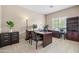 Well-lit home office featuring a dark wood desk, rolling chair, and functional built-in shelving at 3488 N Lady Lake Ln, Casa Grande, AZ 85122