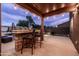 Covered outdoor bar area with stone accents, lighting, and seating at 3488 N Lady Lake Ln, Casa Grande, AZ 85122
