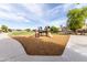 Community playground surrounded by wood chip base and a concrete walking path at 3488 N Lady Lake Ln, Casa Grande, AZ 85122