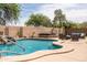 Sparkling pool with rock waterfall feature next to a hot tub and outdoor seating at 3488 N Lady Lake Ln, Casa Grande, AZ 85122