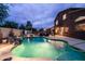Stunning backyard pool with rock feature, spa, and outdoor seating under a covered patio, perfect for evening relaxation at 3488 N Lady Lake Ln, Casa Grande, AZ 85122