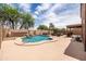 Beautiful kidney-shaped pool with waterfall feature, lounge area, and outdoor kitchen under a pergola at 3488 N Lady Lake Ln, Casa Grande, AZ 85122