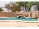Close up of the backyard pool with a waterfall feature, rock accents, and desert landscaping at 3488 N Lady Lake Ln, Casa Grande, AZ 85122