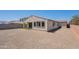 The backyard has gravel, turf and a view of the rear of the house under a clear sky at 4467 S 116Th Ln, Avondale, AZ 85323