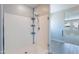 Modern glass shower featuring white tile, a mounted shower head, and an open entry for accessibility at 4467 S 116Th Ln, Avondale, AZ 85323