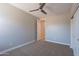 This bedroom features neutral walls, neutral carpet, a ceiling fan, and a closet for easy storage at 4467 S 116Th Ln, Avondale, AZ 85323
