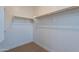 Walk-in closet offers ample storage space, with wooden racks and carpeting for a tidy storage solution at 4467 S 116Th Ln, Avondale, AZ 85323