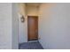 A charming brown wooden front door framed by textured walls and a sleek, modern lantern at 4467 S 116Th Ln, Avondale, AZ 85323