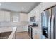 This well-lit kitchen offers stainless steel appliances, ample counter space, white cabinets, and a stylish tile backsplash at 4467 S 116Th Ln, Avondale, AZ 85323