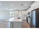 The spacious kitchen boasts white cabinetry, stainless steel appliances, and an island, seamlessly flowing into the dining area at 4467 S 116Th Ln, Avondale, AZ 85323