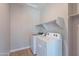 The spacious laundry room offers a washer, dryer and shelving for storage at 4467 S 116Th Ln, Avondale, AZ 85323