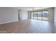 Open-concept living room boasts wood-look tile flooring and expansive glass doors to the back patio and yard at 4467 S 116Th Ln, Avondale, AZ 85323