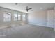 Spacious main bedroom with plush carpet, three sunny windows and a ceiling fan for comfortable climate control at 4467 S 116Th Ln, Avondale, AZ 85323
