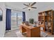 Cozy office with a wooden desk, ceiling fan, built-in bookshelves, and plush rug at 4632 E Kachina Trl, Phoenix, AZ 85044
