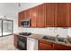 Well-equipped kitchen with cherry cabinets, granite countertops, and stainless steel appliances at 4808 N 24Th St # 231, Phoenix, AZ 85016