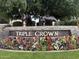 Community entrance sign with stone base, horse sculptures and colorful flowers at 4944 E Villa Theresa Dr, Scottsdale, AZ 85254