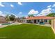 Expansive backyard with a pool, grass, and a covered patio, perfect for outdoor living at 4953 W Acoma Dr, Glendale, AZ 85306