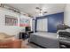 Cozy bedroom with gray walls, a ceiling fan, and large TV at 4953 W Acoma Dr, Glendale, AZ 85306