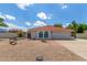 Charming single-story home featuring a red tile roof, arched windows, and a low-maintenance desert landscape at 4953 W Acoma Dr, Glendale, AZ 85306