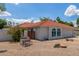 Charming single-story home featuring a red tile roof, arched windows, and a low-maintenance desert landscape at 4953 W Acoma Dr, Glendale, AZ 85306